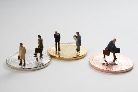 Téléchargez les photos : Figurines miniatures d'hommes d'affaires debout sur Bitcoins - en image libre de droit