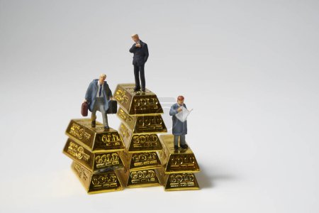 Foto de Figuras de hombres de negocios y barras de oro sobre blanco - Imagen libre de derechos