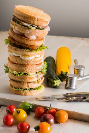 Photo for Pile of homemade sandwiches with chicken breast, lettuce, cheese, eggs and shrimps - Royalty Free Image