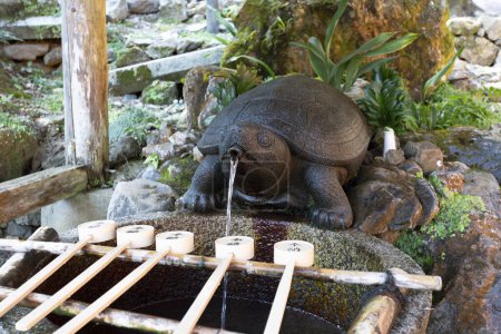 une statue de tortue buvant l'eau d'une fontaine