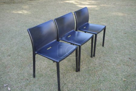 Photo for Black plastic chairs in the garden - Royalty Free Image