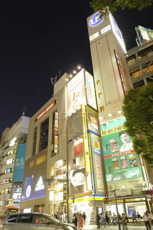 Foto de Calle iluminada con edificio comercial en la ciudad de Tokio por la noche, Japón - Imagen libre de derechos