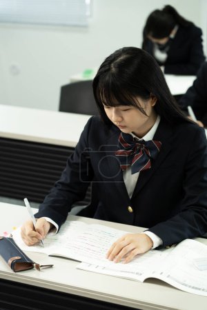 Photo for Female Japanese student studying in classroom - Royalty Free Image