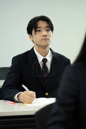 Foto de Japonés estudiante de escuela masculina estudiando en el aula - Imagen libre de derechos
