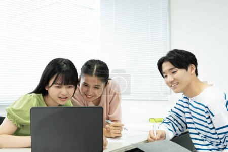 Téléchargez les photos : Japonais étudiants utilisant un ordinateur portable - en image libre de droit