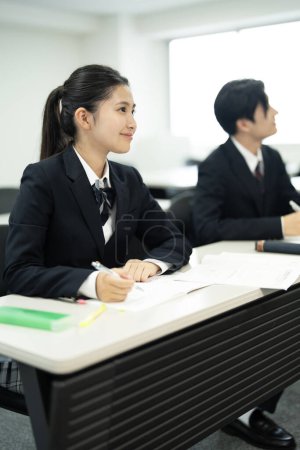 Foto de Estudiantes de escuela japonesa en uniforme estudiando en el aula - Imagen libre de derechos