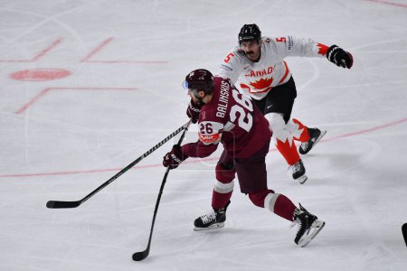 Foto de LETONIA, RIGA - 12.05.23: BALINSKIS Uvis Janis, MIDDLETON Jacob. Game Letonia - Canadá. IIHF 2023 Campeonato Mundial de Hockey sobre Hielo - Imagen libre de derechos