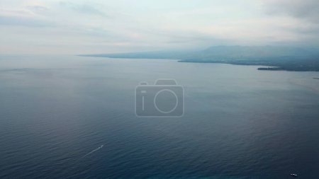 Téléchargez les photos : Vue aérienne d'un yacht naviguant dans l'océan entre deux îles. L'océan bleu sur fond de hauts plateaux de l'île de Lombok. Vacances en mer et un voyage sur un yacht sur l'océan. - en image libre de droit