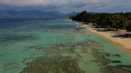 Téléchargez les photos : Belle vue sur une petite île avec des montagnes en arrière-plan. Une île au milieu de l'océan Indien près de Bali. Océan turquoise et hautes montagnes, volcans. - en image libre de droit