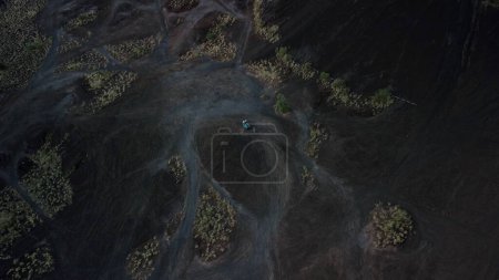 Téléchargez les photos : Vue aérienne des touristes qui voyagent à travers le volcan dans une jeep rétro. Indonésie, Bali, volcan Batur, un groupe de touristes est photographié dans une voiture hors route sur le fond du volcan. - en image libre de droit