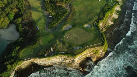 Photo for Drone footage of a group of people playing golf at a country club perched on a cliff by the ocean. Green golf course on the coast, people play golf. High quality 4k footage. - Royalty Free Image
