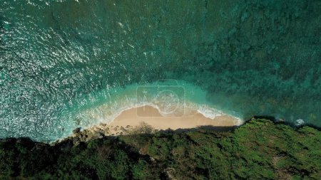 Foto de Vista de arriba hacia abajo de una pequeña playa en el océano, desde la parte posterior de la playa un acantilado. Green Ball Beach en Bali en la zona de Uluwatu, un lugar popular para el surf. Maravillosa naturaleza fondo foto. - Imagen libre de derechos