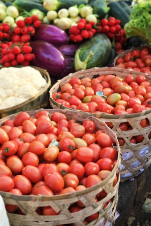 Foto de Banner fotográfico vertical con varias verduras frescas en un mercado de agricultores orgánicos en el sudeste asiático. Verduras y frutas orgánicas en un mercado callejero asiático. Verduras en cestas de mimbre. - Imagen libre de derechos