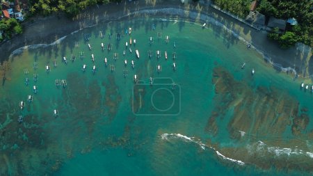 Photo for Aerial view of fishing boats parked off the shore of the tropical island of Bali. Colorful fishermens boats near the beach, top-down view. Adventure and travel concept. - Royalty Free Image