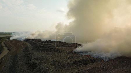 Téléchargez les photos : Piloter un drone au-dessus d'un incendie survenu dans une décharge de l'île de Bali. Les déchets plastiques brûlent, une véritable catastrophe environnementale. Recyclage et élimination des déchets. - en image libre de droit