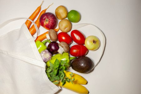 Lebensmitteleinkaufskonzept und Null-Abfall-Konzept. Frisches Gemüse und Obst in einer wiederverwendbaren Öko-Baumwolltasche. Ansicht von oben, Kopierraum.