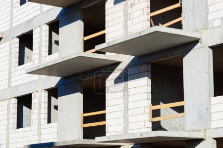 Téléchargez les photos : Shell structure de l'immeuble d'appartements murs de briques en béton armé mandrin et balcon close up - en image libre de droit