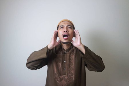 Religious Muslim man reads in the ear azan or iqamah isolated over white background