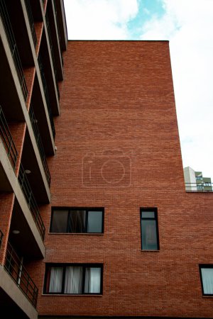 Foto de Foto vertical de una parte de la fachada del edificio de ladrillo con balcones y ventanas - Imagen libre de derechos