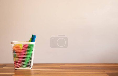 Foto de Cesta para bolígrafos colorida sobre mesa de madera aislada sobre fondo blanco con distancia o espacio de copia. - Imagen libre de derechos