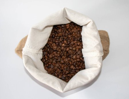 Foto de Granos de café en el saco. Granos de café en el saco aislados sobre fondo blanco - Imagen libre de derechos