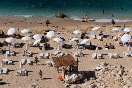 Foto de Playa llena de gente. Gente en el mar azul y ondulado con hermosa arena en la playa llena de gente. - Imagen libre de derechos