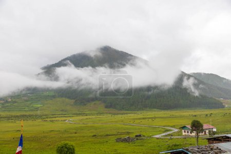 Foto de Vista panorámica del valle de Phobjikha en un día nublado en Bután, paisaje con nubes sobre las montañas. - Imagen libre de derechos