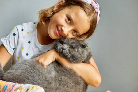 Teen girl with a broken arm orthopedic cast play with cat at home, love pets.