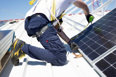 Foto de Un trabajador mide paneles solares con un medidor para instalarlos en la azotea - Imagen libre de derechos