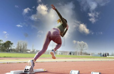 Photo for Sprinter taking off from starting block on running track - Royalty Free Image