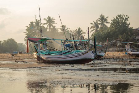 Photo for Fishing boats are stranded on the beach because sea water recedes in the morning - Royalty Free Image