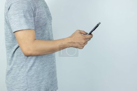 Foto de Hombre asiático enviando mensaje de texto en el teléfono inteligente en fondo blanco - Imagen libre de derechos