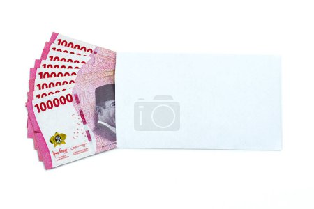 Indonesian rupiah currency. White envelope containing IDR 100,000 in cash isolated on white background