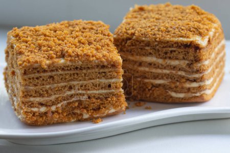 Téléchargez les photos : Morceaux de gâteau au miel sur une assiette blanche, dessert, pâtisserie sucrée - en image libre de droit