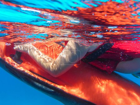 Téléchargez les photos : Un garçon en gilet de sauvetage rouge nage avec un scooter sous-marin au large des côtes de l'île d'ANTIPAXOS, plage de Voutoumi, îles Ioniennes, Grèce en été. Horizontal. Gros plan. - en image libre de droit