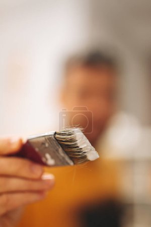 Photo for Defocused man painting camera lens. authentic painter. small art business concept. - Royalty Free Image
