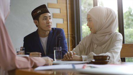 Foto de Upwardly mobile Asian Muslim business businesseur SME start up group of young man and women, discutiendo venta y análisis de marketing, Asian Muslim SME teamwork e-commerce concept - Imagen libre de derechos