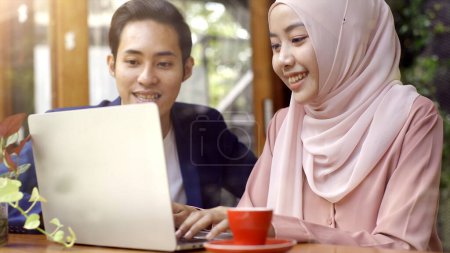 Photo for Upwardly mobile Asian Muslim business entrepreneur SME start up group of young man and women, discussing sale and marketing analysis, Asian Muslim SME teamwork e-commerce concept - Royalty Free Image