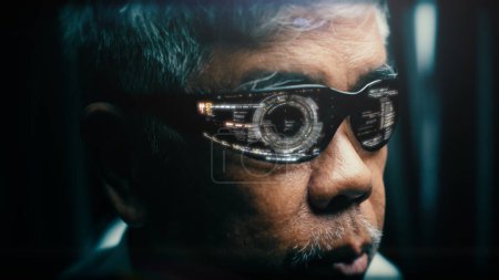 Téléchargez les photos : Un Asiatique majeur portant des lunettes holo futuristes avec une infographie projetée sur les lunettes. Concept : Réalité virtuelle - en image libre de droit