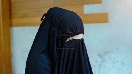 Photo for Portrait of an Asian muslim woman in a daily prayer at home reciting Surah al-Fatiha passage of the Qur'an in a single act of Sujud called a Sajdah or prostration - Royalty Free Image