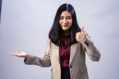 Photo for Portrait of a young Asian business woman showing thumb up, studio shot, business concept, isolated background - Royalty Free Image
