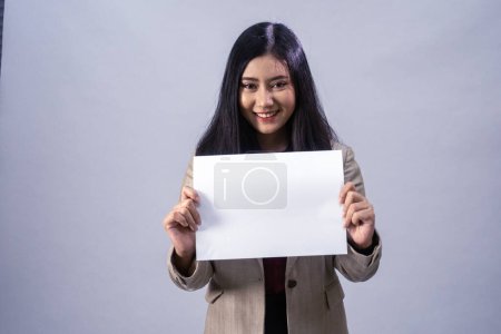 Téléchargez les photos : Portrait d'une jeune femme d'affaires asiatique avec feuille blanche, plan studio, concept d'entreprise, arrière-plan isolé - en image libre de droit