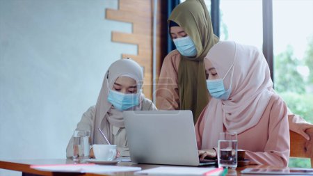 Téléchargez les photos : Vers le haut mobile Asiatique musulman entrepreneur PME démarrage groupe de jeunes femmes, discuter de vente et de marketing analyse, Asiatique musulman PME travail d'équipe e-commerce concept - en image libre de droit