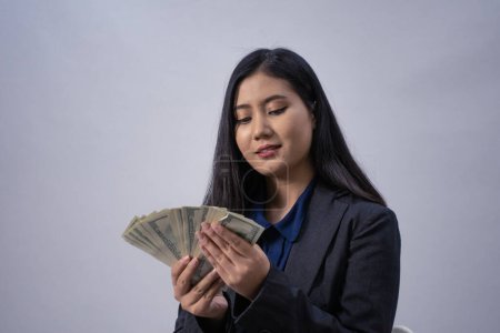 Téléchargez les photos : Portrait d'une jeune femme d'affaires asiatique avec de l'argent, plan de studio, concept d'entreprise, arrière-plan isolé - en image libre de droit