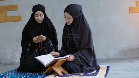 Photo for Portrait of an Asian muslim women in a daily prayer at home reciting Surah al-Fatiha passage of the Qur'an in a single act of Sujud called a Sajdah or prostration - Royalty Free Image