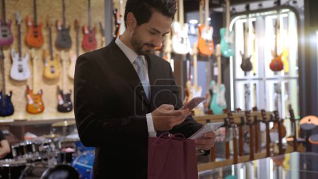 Photo for An upwardly mobile Muslim man using smart payment to pay for a product at a sale terminal with nfc identification payment for verification and authentication - Royalty Free Image