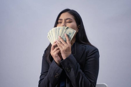 Foto de Retrato de una joven mujer de negocios asiática con dinero, plano de estudio, concepto de negocio, fondo aislado - Imagen libre de derechos