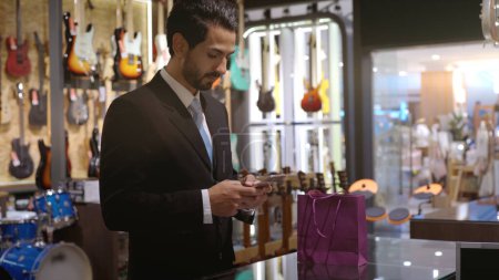 Foto de Un musulmán móvil ascendente que utiliza el pago inteligente para pagar un producto en una terminal de venta con pago de identificación nfc para verificación y autenticación - Imagen libre de derechos