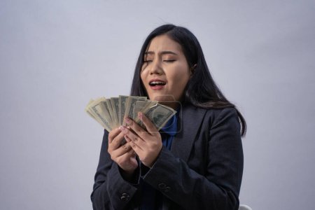 Téléchargez les photos : Portrait de style de vie d'une jeune femme d'affaires asiatique avec de l'argent, plan de studio, concept d'entreprise, arrière-plan isolé - en image libre de droit