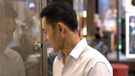 Photo for Close Up Portrait of a South East Asian Muslim man looking for a product in the shop window - Royalty Free Image